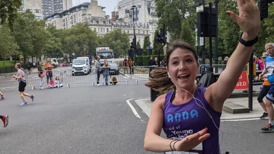 A runner participating in the Royal Parks Half Marathon raises a hand for a high-five.